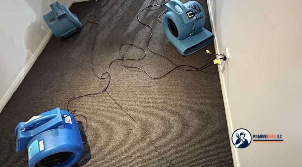 Blue air movers positioned on carpet to speed up drying after water damage restoration.